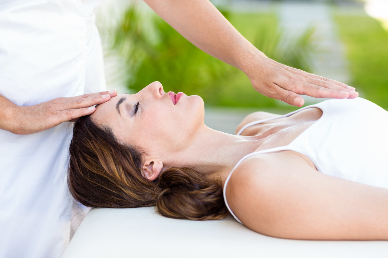 Clinical hypnotherapy session with a practitioner guiding a woman through relaxation.
